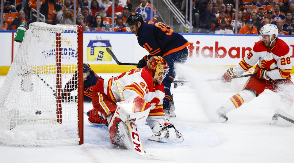 Calgary Flames goalie Jacob Markstrom, left, lets in a goal from Edmonton Oilers winger Evander Kane during the second period of an NHL hockey Stanley Cup second-round playoff series game in Edmonton, Alberta, Sunday, May 22, 2022. (Jeff McIntosh/The Canadian Press via AP)