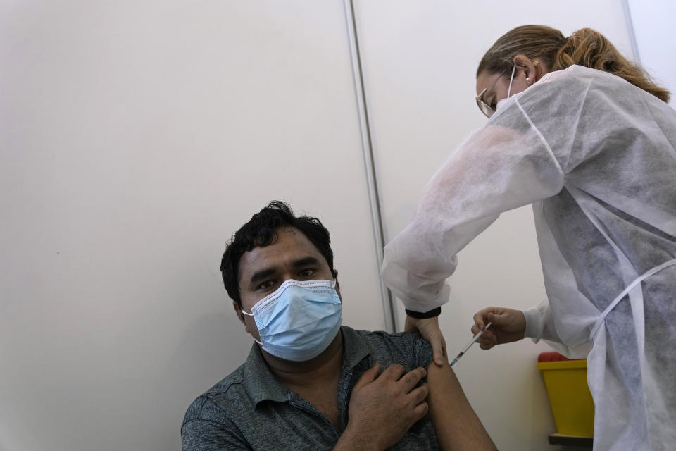 A military nurse administers a dose of the Pfizer coronavirus vaccine at a vaccination center in Lisbon, Tuesday, Sept. 21, 2021. As Portugal nears its goal of fully vaccinating 85% of the population against COVID-19 in nine months, other countries want to know how it was able to accomplish the feat. A lot of the credit is going to Rear Adm. Henrique Gouveia e Melo. (AP Photo/Armando Franca)