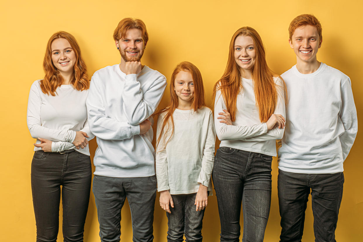 photo showing a beautiful unusual brothers and sisters with red hair, smiling at camera, feel happy together. relatives, family. people concept