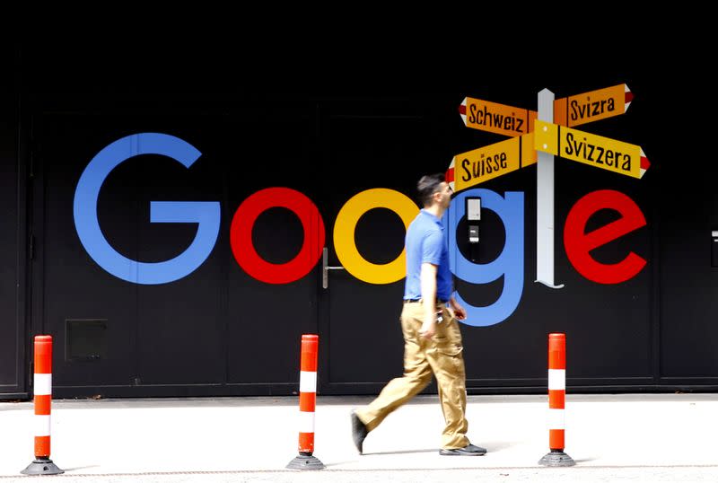 FILE PHOTO: A man walks past a logo of Google in Zurich