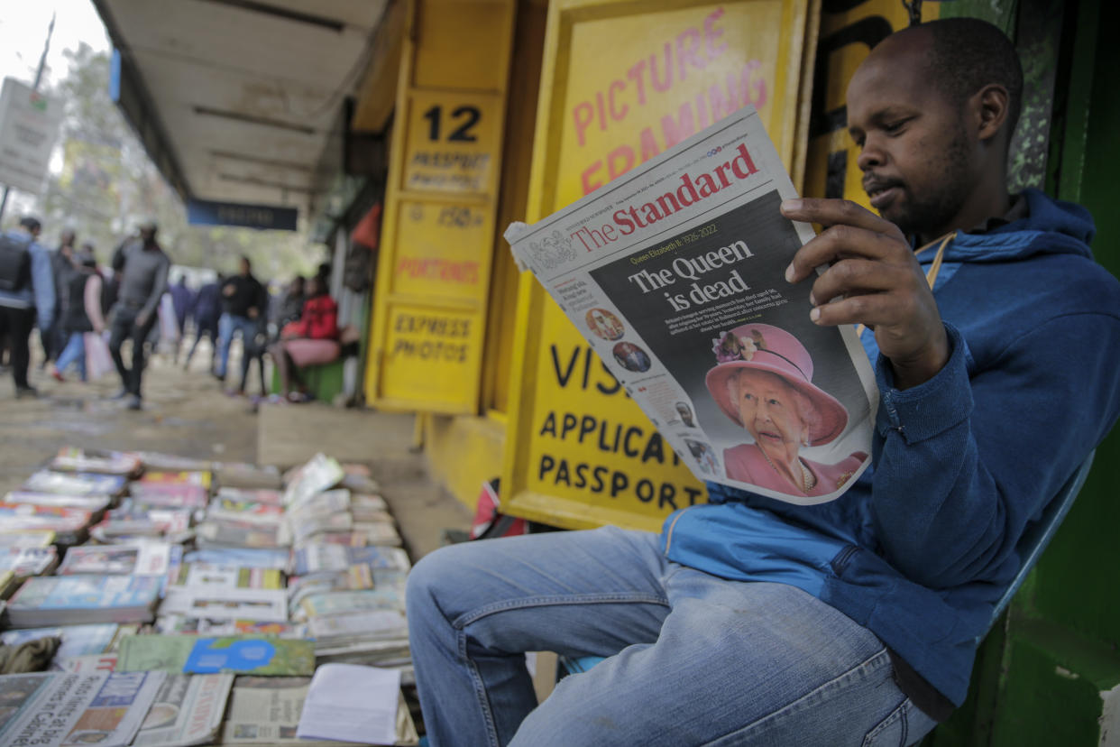 A vendor reads a newspaper showing coverage of the death of Queen Elizabeth II, in downtown Nairobi, Kenya on Friday, Sept. 9, 2022. (AP Photo/Brian Inganga)