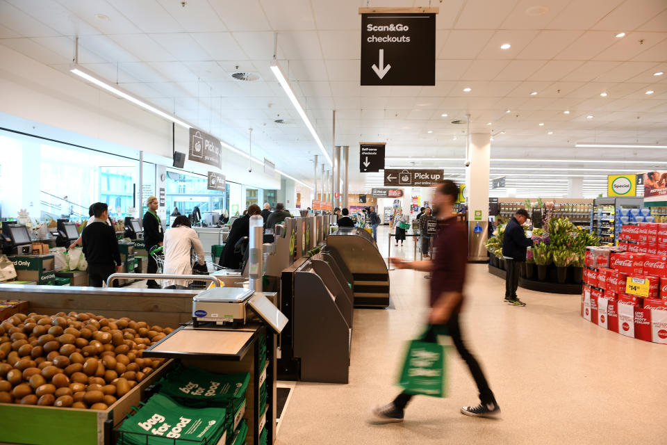 A man walks towards a Woolworths checkout. 