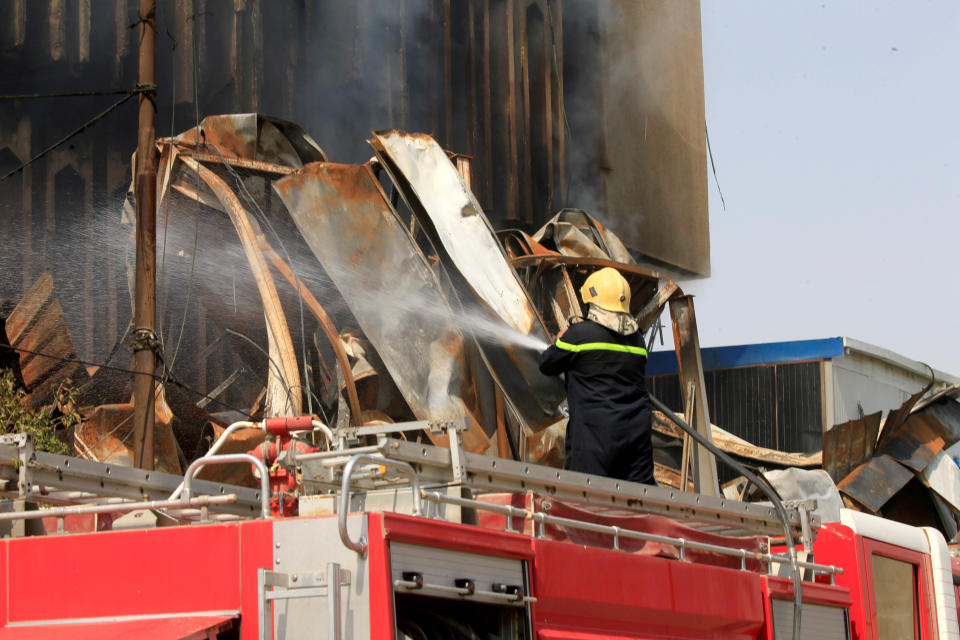 A fireman hoses down a burning government building in Basra