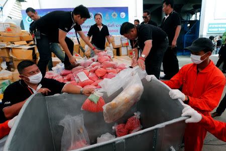 Thai narcotics officials put bags of methamphetamine pills into a bin during the 47th Destruction of Confiscated Narcotics ceremony in Ayutthaya province, north of Bangkok, Thailand June 26, 2017. REUTERS/Chaiwat Subprasom