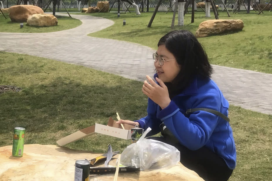 In this photo taken April 14, 2020 and released by Melanie Wang, Zhang Zhan eats a meal at a park during a visit to Wuhan in central China's Hubei province. A Chinese court on Monday sentenced the former lawyer who reported on the early stage of the coronavirus outbreak to four years in prison on charges of "picking fights and provoking trouble," one of her lawyers said. (Melanie Wang via AP)