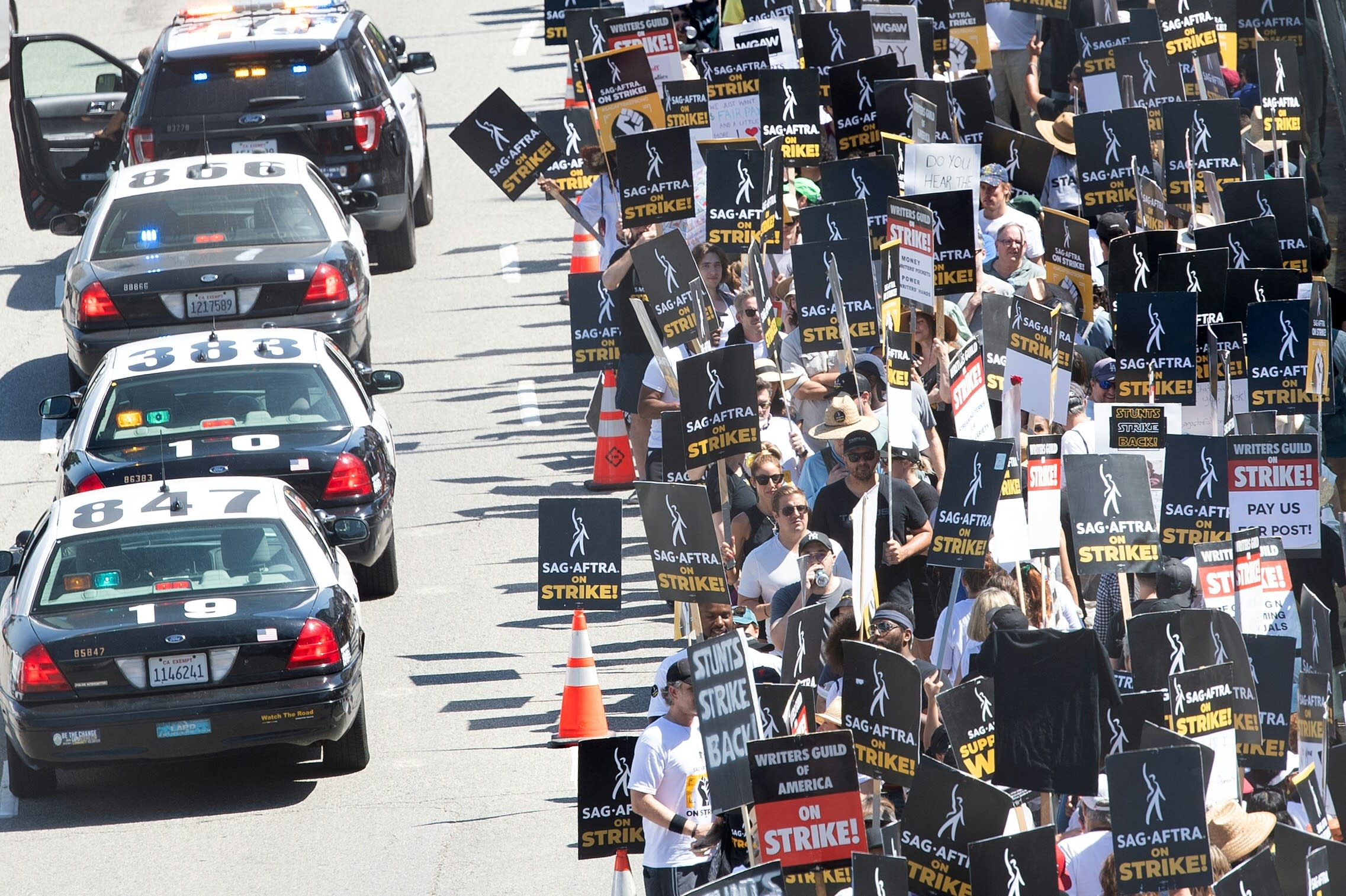 Members of the Writers Guild of America and the Screen Actors Guild walk the picket line outside Universal Studios in Burbank, Calif., in August 2023.