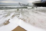 SEASIDE HEIGHTS, NJ - NOVEMBER 16: Waves break in front of a destroyed roller coaster on November 16, 2012 in Seaside Heights, New Jersey. Two amusement piers and a number of roller coasters in the seaside town were destroyed by Superstorm Sandy. (Photo by Mario Tama/Getty Images)