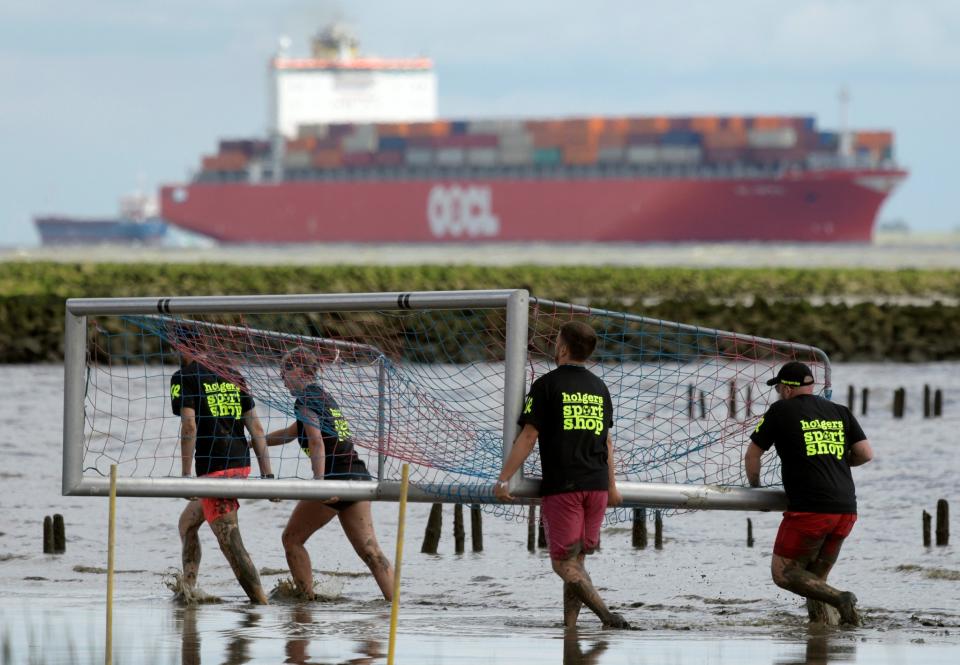 <p>Participants carry a goal during preparations for “Wattoluempiade” (Mud Olympics) in Brunsbuettel at the North Sea, Germany July 30, 2016. (REUTERS/Fabian Bimmer) </p>