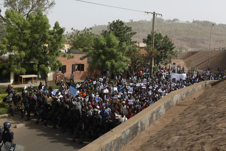 People march along a central street as thousands rallied in a show of support for the recent military coup, in Bamako, Mali Wednesday, March 28, 2012. The body representing nations in western Africa has suspended Mali and has put a peacekeeping force on standby in the most direct threat yet to the junta that seized control of this nation in a coup last week. (AP Photo/Rebecca Blackwell)