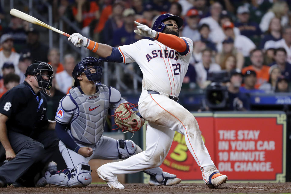 Houston Astros first baseman Jon Singleton, right, watches his two-run home run in front of umpire Mark Carlson, left, and Cleveland Guardians catcher Bo Naylor, center, during the sixth inning of a baseball game Thursday, May 2, 2024, in Houston. (AP Photo/Michael Wyke)