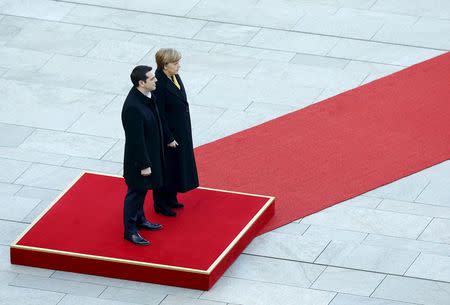 German Chancellor Angela Merkel (R) and Greek Prime Minister Alexis Tsipras review an honour guard during a welcoming ceremony at the Chancellery in Berlin, Germany in this March 23, 2015 file photo. REUTERS/Pawel Kopczynski/Files