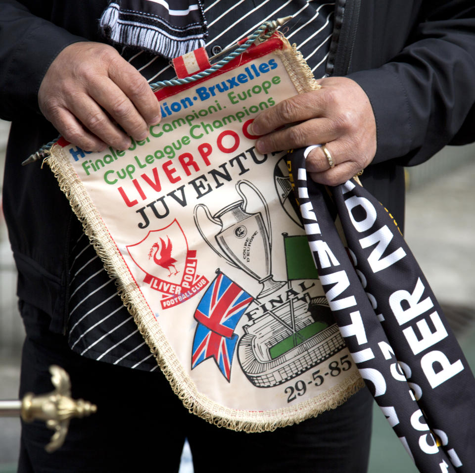 FILE - In this May 29, 2015 file photo, Italy's Domenico Di Bernardo holds an original banner from the 1985 match during a commemoration at the King Boudouin (formerly the Heysel) Stadium in Brussels. Friday, May 29, 2020 marks 35 years since 39 victims lost their lives during a European Cup football match between Liverpool and Juventus due to a surge of rival supporters resulting in a collapsed wall. (AP Photo/Virginia Mayo, File)