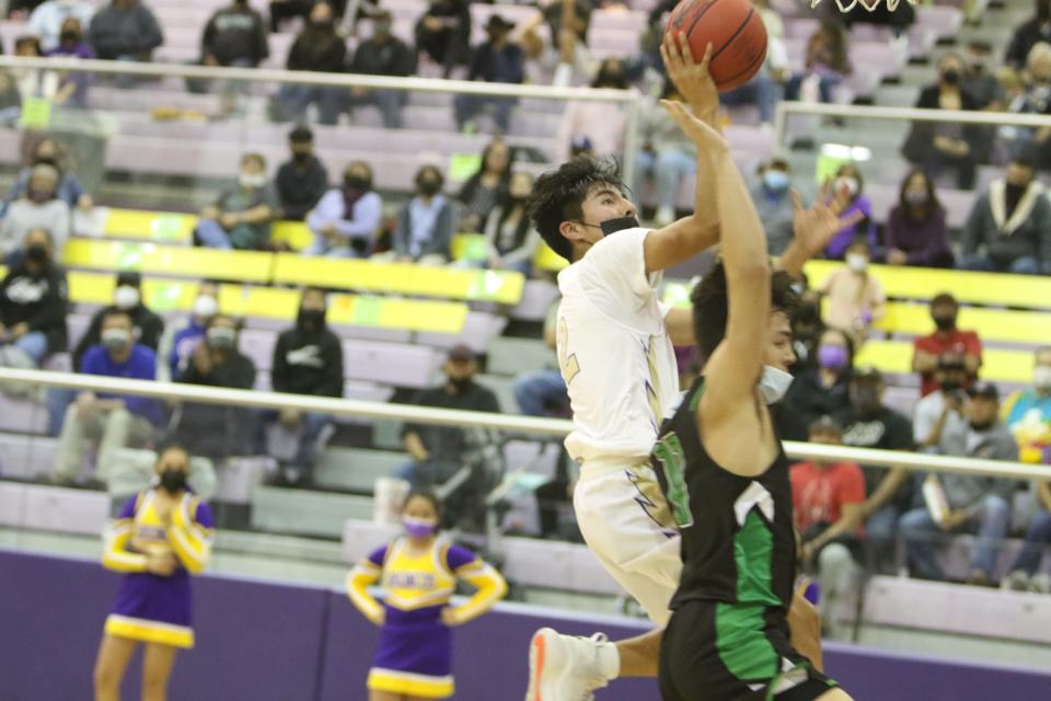 Kirtland Central's Satchel Hogue (left) drives to the basket against Farmington's Marcos Araiza during a game at Bronco Arena, Tuesday, Dec. 7, 2021.