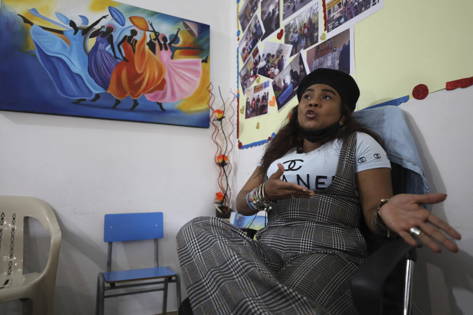 Community leader Luz Nelly Santana, whose life has been threatened by illegal armed groups, talks during an interview in Bogota, Colombia, Thursday, Dec. 17, 2020. Santana and her daughter survived a massacre where 35 people were killed during a street party and decided to flee to the capital where she has lived ever since. (AP Photo/Fernando Vergara)