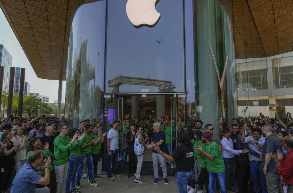 Apple CEO Tim Cook center, welcomes a visitor during the opening of the first Apple Inc. flagship store in Mumbai, India, Tuesday, April 18, 2023. Apple Inc. opened its first flagship store in India in a much-anticipated launch Tuesday that highlights the company’s growing aspirations to expand in the country it also hopes to turn into a potential manufacturing hub. (AP Photo/Rafiq Maqbool)