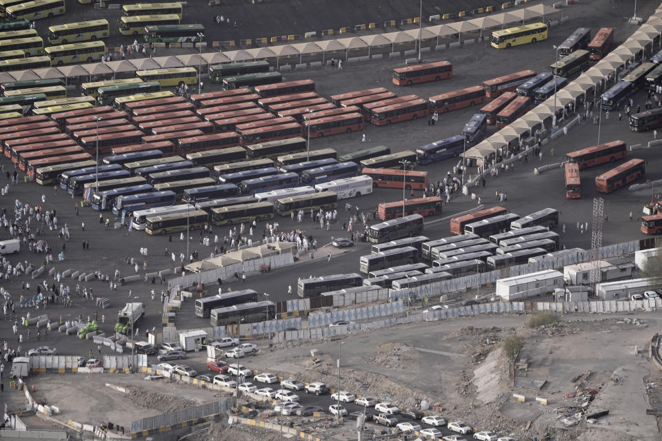 People walk at a giant bus station outside the Grand mosque in the Muslim holy city of Mecca, Saudi Arabia, Thursday, June 22, 2023. Mecca is Islam's most sacred city and a focal point for the faith's followers. But it's also a place where around 2 million people live, work, and do everyday activities like laundry, grocery shopping, homework, putting the trash out, and paying the bills. Traffic, the population, and prices balloon during the peak Ramadan and Hajj seasons. (AP Photo/Amr Nabil)