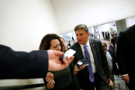 Reporters trail U.S. Senator Joe Manchin (D-WV) as he arrives ahead of a vote on a bill to renew the National Security Agency's warrantless internet surveillance program, at the U.S. Capitol in Washington, U.S. January 18, 2018. REUTERS/Jonathan Ernst