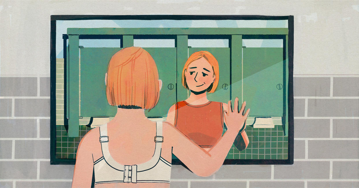 An illustration shows the back of a light-skinned person with short strawberry blonde hair in a wired bra, with their hand on a mirror. In the reflection, they are wearing an orange sports bra. Green bathroom stalls are in the background. 