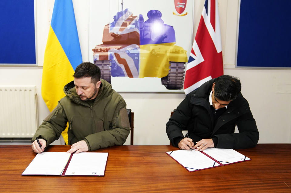 Ukrainian President Volodymyr Zelensky, left, and British Prime Minister Rishi Sunak sign a declaration of unity at a military facility in Lulworth, Dorset, England, Wednesday Feb. 8, 2023. (Andrew Matthews/Pool via AP)
