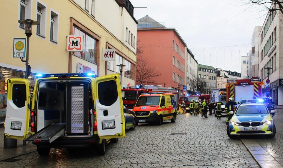 Emergency services from the police, fire department and ambulance stand at the scene of an accident in the city center in Passau, Germany (AP)