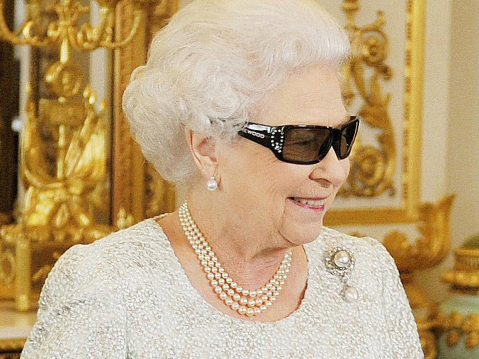 Queen Elizabeth watches a preview of her Christmas message wearing a pair of 3D glasses, studded with Swarovski crystals in the form of a 