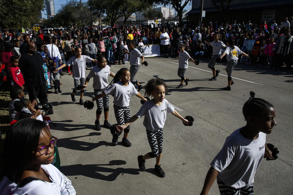 In this Monday, Jan. 15, 2018 photo, the Isiserettes perform during a break in the MLK Grande Parade as emergency crews worked to extinguish a fire along the parade route in Houston. For more than two decades, competing MLK Day parades have been held in Houston. This year, the city of Houston threw its official support behind one parade, the 41st annual “Original” MLK, Jr. Parade, hoping the city could unite behind only one parade. But organizers of the other parade, the 25th annual MLK Grande Parade, will still be holding its event and they say they have no plans to stop having their own parade. (Michael Ciaglo/Houston Chronicle via AP)