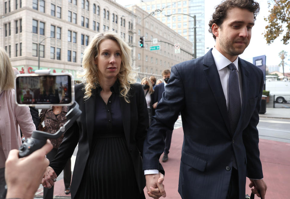 SAN JOSE, CALIFORNIA - NOVEMBER 18: Former Theranos CEO Elizabeth Holmes (L) arrives at federal court with her partner Billy Evans (R) on November 18, 2022 in San Jose, California. Holmes appeared in federal court for sentencing after being convicted of four counts of fraud for allegedly engaging in a multimillion-dollar scheme to defraud investors in her company Theranos, which offered blood testing lab services. (Photo by Justin Sullivan/Getty Images)