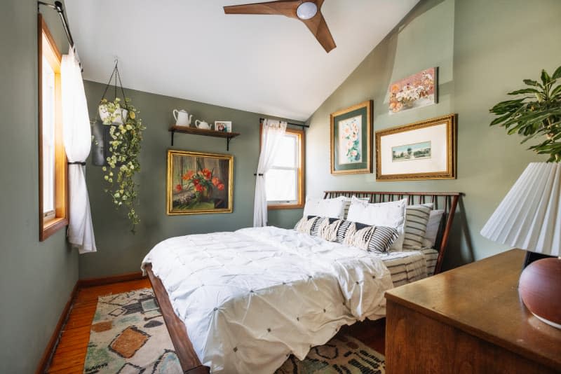 Green walls in a bedroom with a white ceiling and wood accents