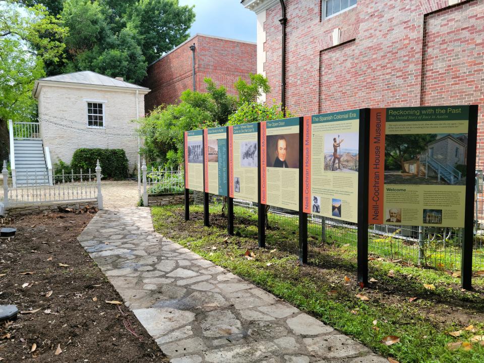 The path leading to the slave quarters at the Neill-Cochran House is now lined with large interpretive panels that explain not only the structure, but also the context of slavery in Texas and Austin.