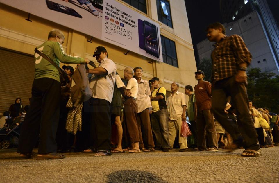 The needy queuing for food distributed by the Pertiwi Soup Kitchen at Chow Kit in Kuala Lumpur yesterday. – The Malaysian Insider pic by Nazir Sufari, July 5, 2014.