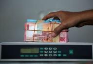 Indonesian rupiah banknotes are seen after they were counted at a money changer in Jakarta