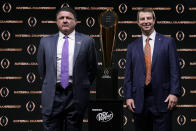 LSU head coach Ed Orgeron, left, and Clemson head coach Dabo Swinney pose with the trophy after a news conference for the NCAA College Football Playoff national championship game Sunday, Jan. 12, 2020, in New Orleans. Clemson is scheduled to play LSU on Monday. (AP Photo/Chris Carlson)