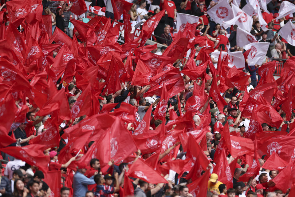 Manchester United fans wave flags ahead of the English FA Cup final soccer match between Manchester City and Manchester United at Wembley Stadium in London, Saturday, May 25, 2024. (AP Photo/Ian Walton)