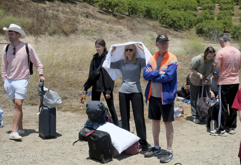 Passengers wait for transportation after their Amtrak train derailed in Moorpark, Calif., on Wednesday, June 28, 2023. Authorities say an Amtrak passenger train carrying 190 passengers derailed after striking a vehicle on tracks in Southern California. Only minor injuries were reported. (Dean Musgrove/The Orange County Register via AP)