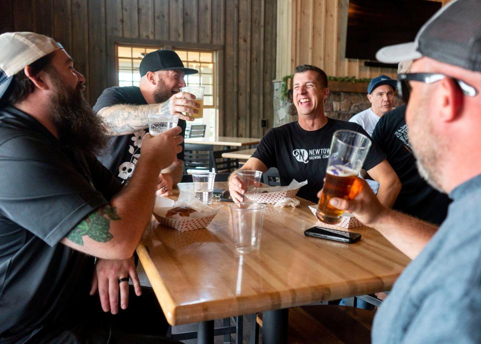 Andrew Balmer, of Broad Street Brewing, on left, with Tim Shaw, of Odd Logic Brewing Co., center left, Greg Bonstein, of Newtown Brewing, center right, and Tim Lohse, of Broad Street Brewing, on right, laughing over pints at the event celebrating the collaboration beer between more than 26 local breweries in Bucks County at Warwick Farm Brewing in Jamison on Tuesday, Aug. 1, 2023.