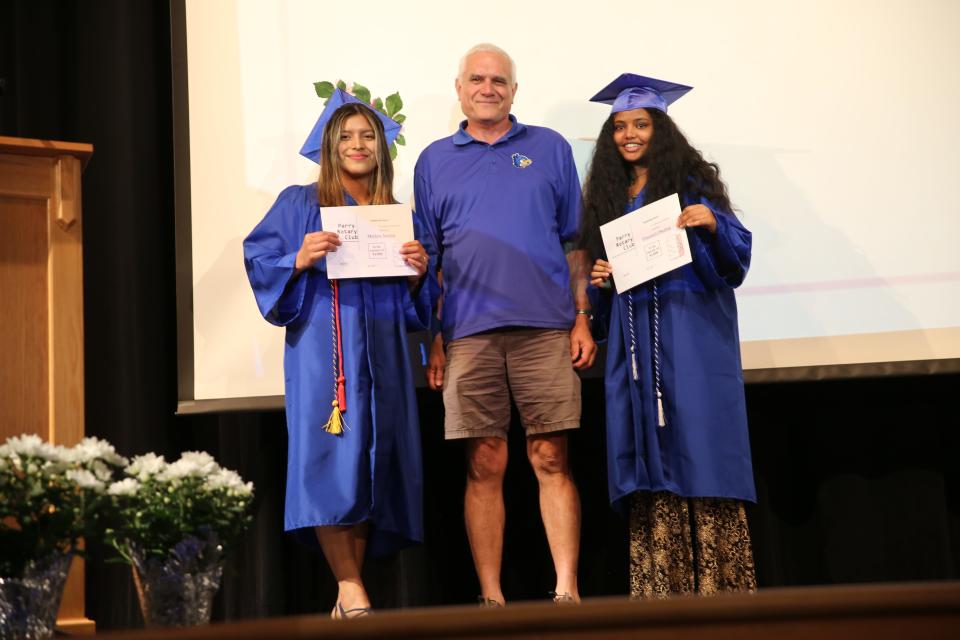 Merlyn Amaya and Filmawit Okubay pose for a photo after receiving a Perry Rotary Club Scholarship from Dirk Cavanaugh during the Senior Awards Assembly on Wednesday, May 17, 2023, at Perry Performing Arts Center.