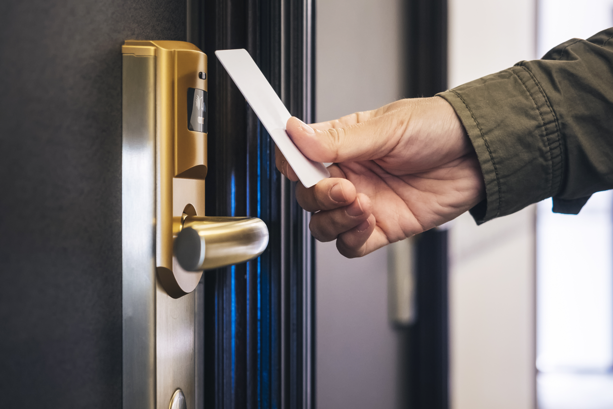 Man opening hotel room door with a room key