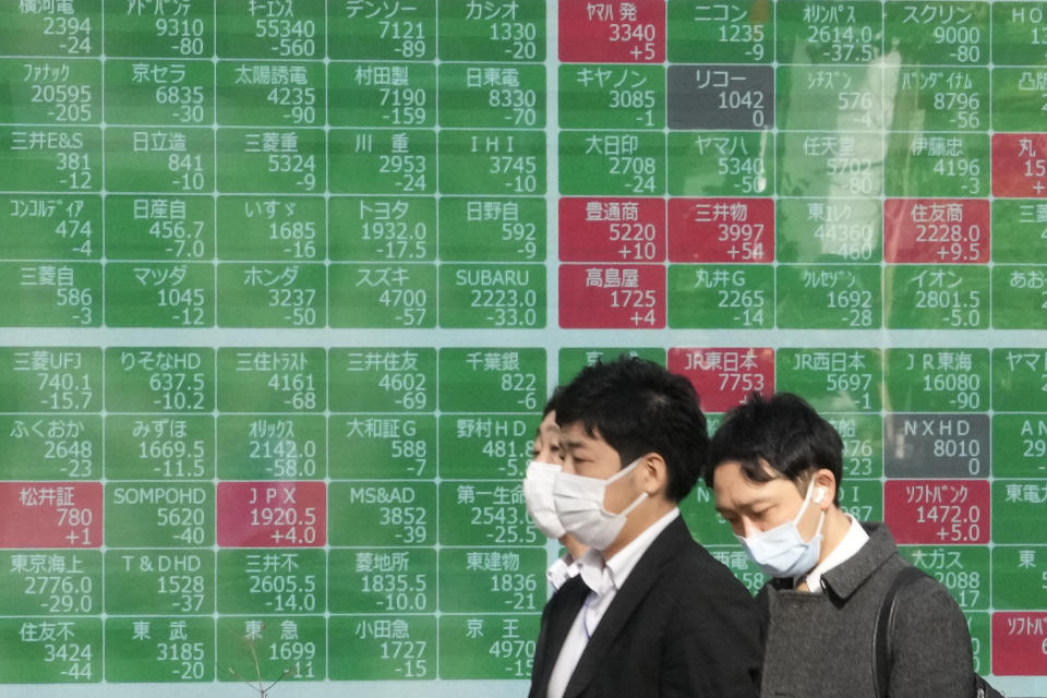 People walk past an electronic stock board showing Japan's stock prices at a securities firm on Dec. 8, 2022, in Tokyo. Shares rose Monday Dec. 26, 2022, in Asia in thin post-Christmas holiday trading, with markets in Hong Kong, Sydney and several other places closed.(AP Photo/Shuji Kajiyama)