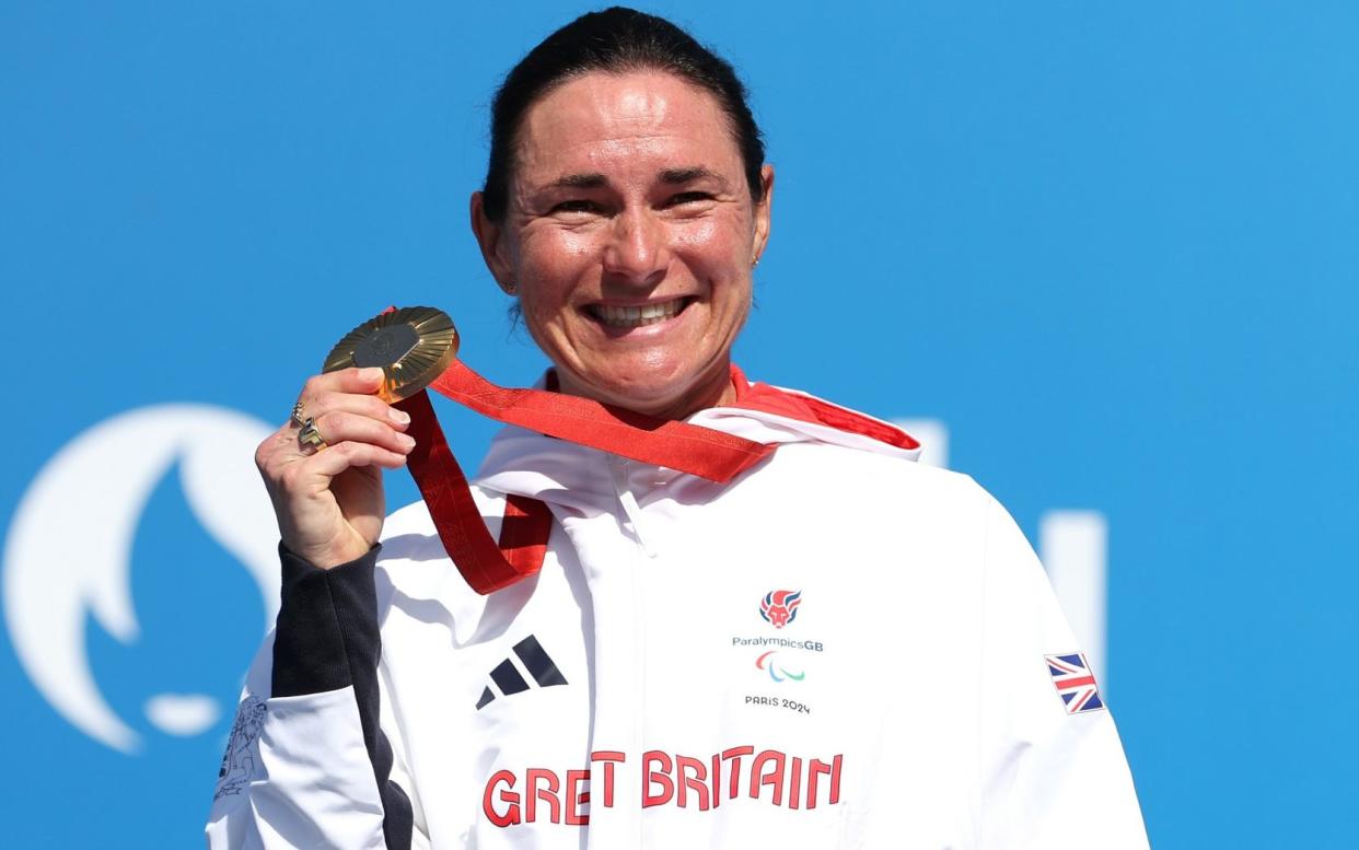 Sarah Storey shows off her gold medal on the podium after the road race at the Paris 2024 Paralympics