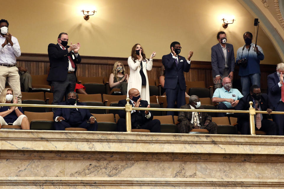 Observers in the House gallery applaud after the lawmakers voted by two-thirds to consider the suspension of the rules and introduce a bill to take down the state flag, Saturday, June 27, 2020 at the Capitol in Jackson, Miss. The resolution now heads to the Senate, where it will also take a two-thirds vote to pass. The current flag has in the canton portion of the banner the design of the Civil War-era Confederate battle flag, that has been the center of a long-simmering debate about its removal or replacement. (AP Photo/Rogelio V. Solis)