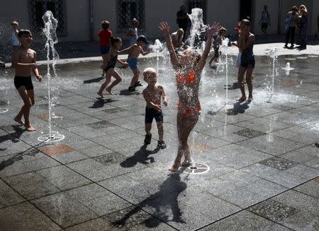 Children play at a fountain on a hot summer day in central Lviv, Ukraine, August 11, 2017. REUTERS/Gleb Garanich/File Photo