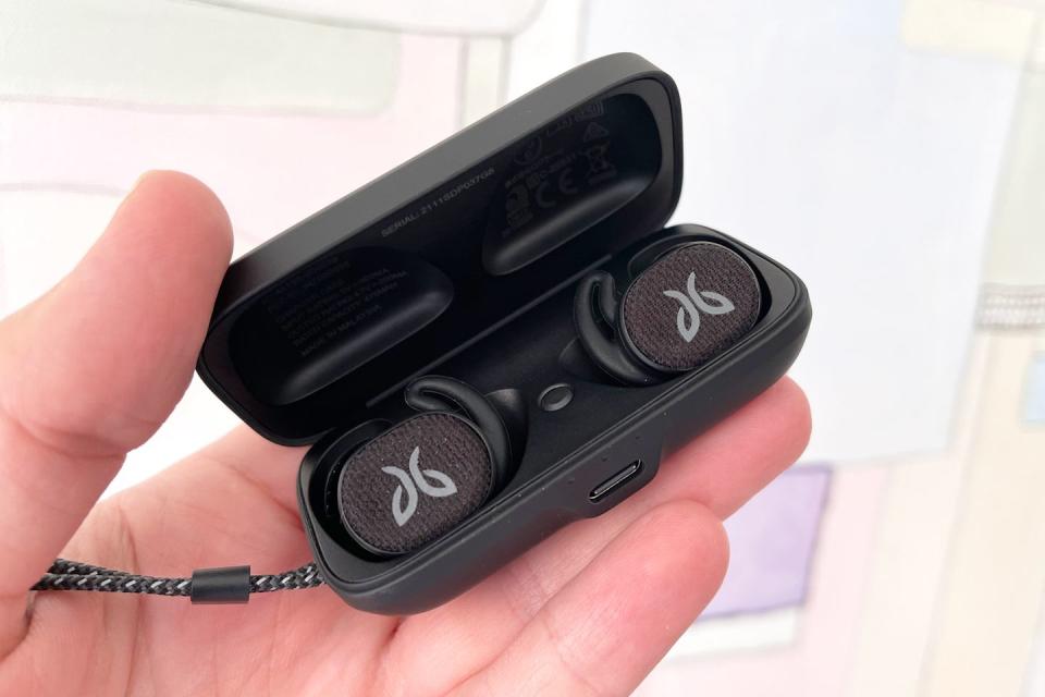 hand holding jaybird vista 2 earbuds in charging case