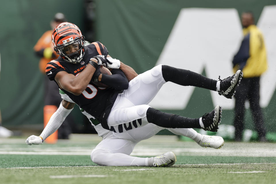 Cincinnati Bengals wide receiver Tyler Boyd (83) is tackled by New York Jets' Michael Carter II in the end zone for a touchdown during the first half of an NFL football game Sunday, Sept. 25, 2022, in East Rutherford, N.J. (AP Photo/Adam Hunger)