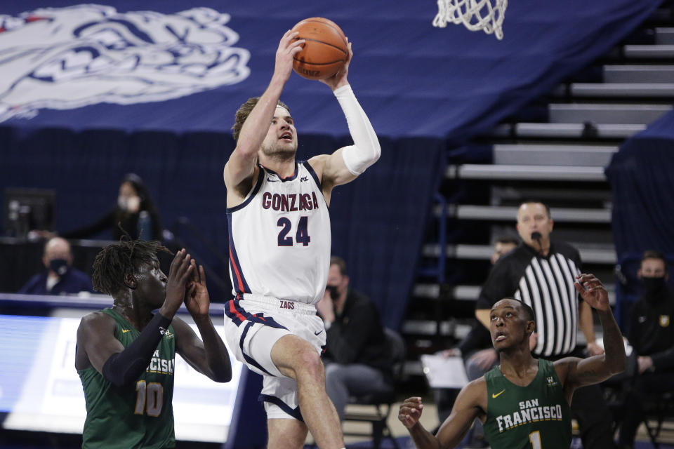 Gonzaga forward Corey Kispert (24) shoots between San Francisco forward Josh Kunen (10) and guard Jamaree Bouyea (1) during the first half of an NCAA college basketball game in Spokane, Wash., Saturday, Jan. 2, 2021. (AP Photo/Young Kwak)