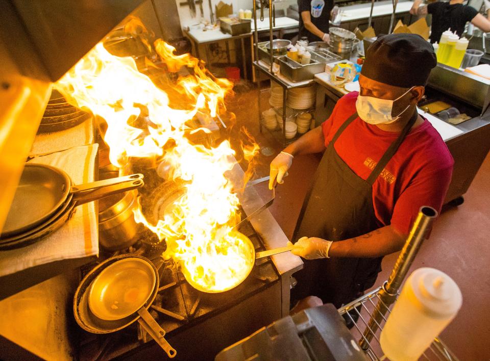 Dwight Miller cooks a to-go order Thursday at Crooked Ewe Brewery and Ale House in South Bend.