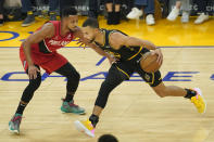Golden State Warriors guard Stephen Curry, right, drives to the basket against Portland Trail Blazers guard CJ McCollum during the first half of an NBA basketball game in San Francisco, Friday, Nov. 26, 2021. (AP Photo/Jeff Chiu)