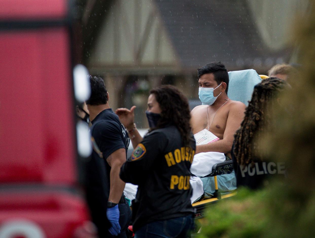 Paramedics carry a man to an ambulance from the scene of a human smuggling case in which more than 90 undocumented immigrants were found inside a home in Houston on April 30, 2021.
