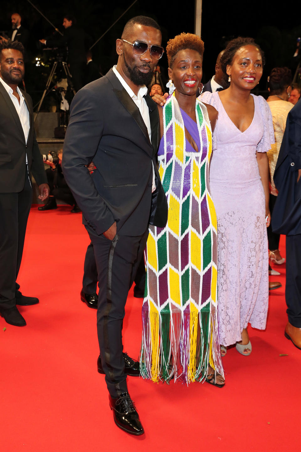 <p>La journaliste Rokhaya Diallo était de retour sur le tapis rouge dans une robe colorée, cette fois pour la projection du film "Nostalgia". Elle. ainsi pu prendre la pose au côté de l'artiste Passi. (Photo by Gisela Schober/Getty Images)</p> 
