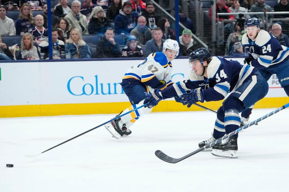 Mar 11, 2023; Columbus, Ohio, USA;  Columbus Blue Jackets center Cole Sillinger (34) reaches for a puck past St. Louis Blues defenseman Torey Krug (47) during the first period of the NHL hockey game at Nationwide Arena. Mandatory Credit: Adam Cairns-The Columbus Dispatch