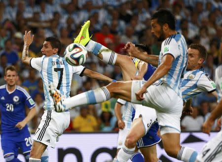 Argentina's Angel Di Maria, Ezequiel Garay and Argentina's Hugo Campagnaro (L-R) lunge for the ball during the 2014 World Cup Group F soccer match against Bosnia and Herzegovina at the Maracana stadium in Rio de Janeiro June 15, 2014. REUTERS/Michael Dalder